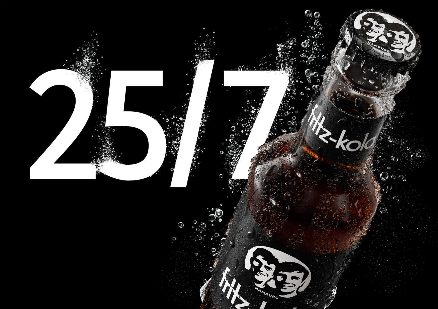 fritz-kola original glasflasche fritz-kola mit kondenswasser vor schwarzem hintergrund, spritzwasser um die flasche, große weiße zahl „25/7“ links im bild