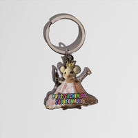 Schlüsselanhänger in Form einer Maus mit goldener Krone und rosa Kleid. Die Maus hält eine kleine Flasche in der linken Hand und einen Sternstab in der rechten. Auf dem Kleid steht in bunten Buchstaben: ‚Prösterchen du Zaubermausi‘.