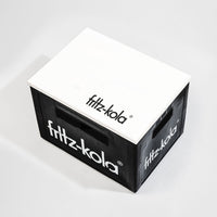 Schwarze fritz-kola Getränkekiste mit weißem Schriftzug an den Seiten, darauf liegt weißer Holz-Deckel mit "fritz-kola" Logo