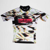 Weißes Radtrikot mit abstraktem Farbverlauf-Muster in Grün, Pink und Schwarz. Zentraler roter Balken mit "radfritzen" auf der Brust, darunter "fritz-kola" Logo. kurze Ärmel, Reißverschluß