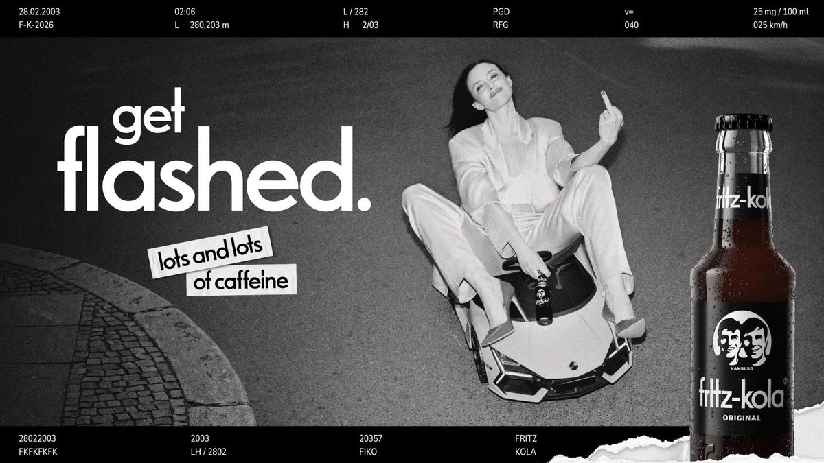 fritz-kola campaign image showing a women in a sports car toy with the slogan “get flashed. lots and lots of caffeine”.