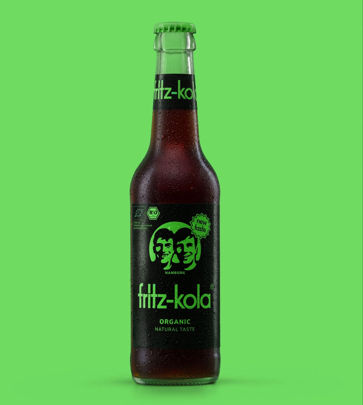 Nieuwe fritz-kola organic in een glazen fles van 0,33 liter voor een groene achtergrond.