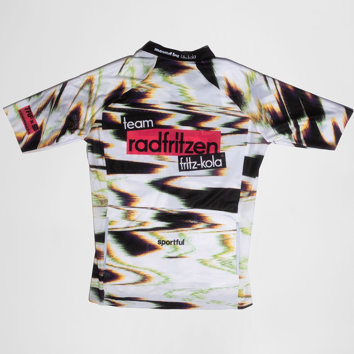 Rückseite Weißes Radtrikot mit abstraktem Farbverlauf-Muster in Grün, Pink und Schwarz. Zentraler roter Balken mit "radfritzen" auf der Brust, darunter  "fritz-kola" Logo. Kurze Ärmel.