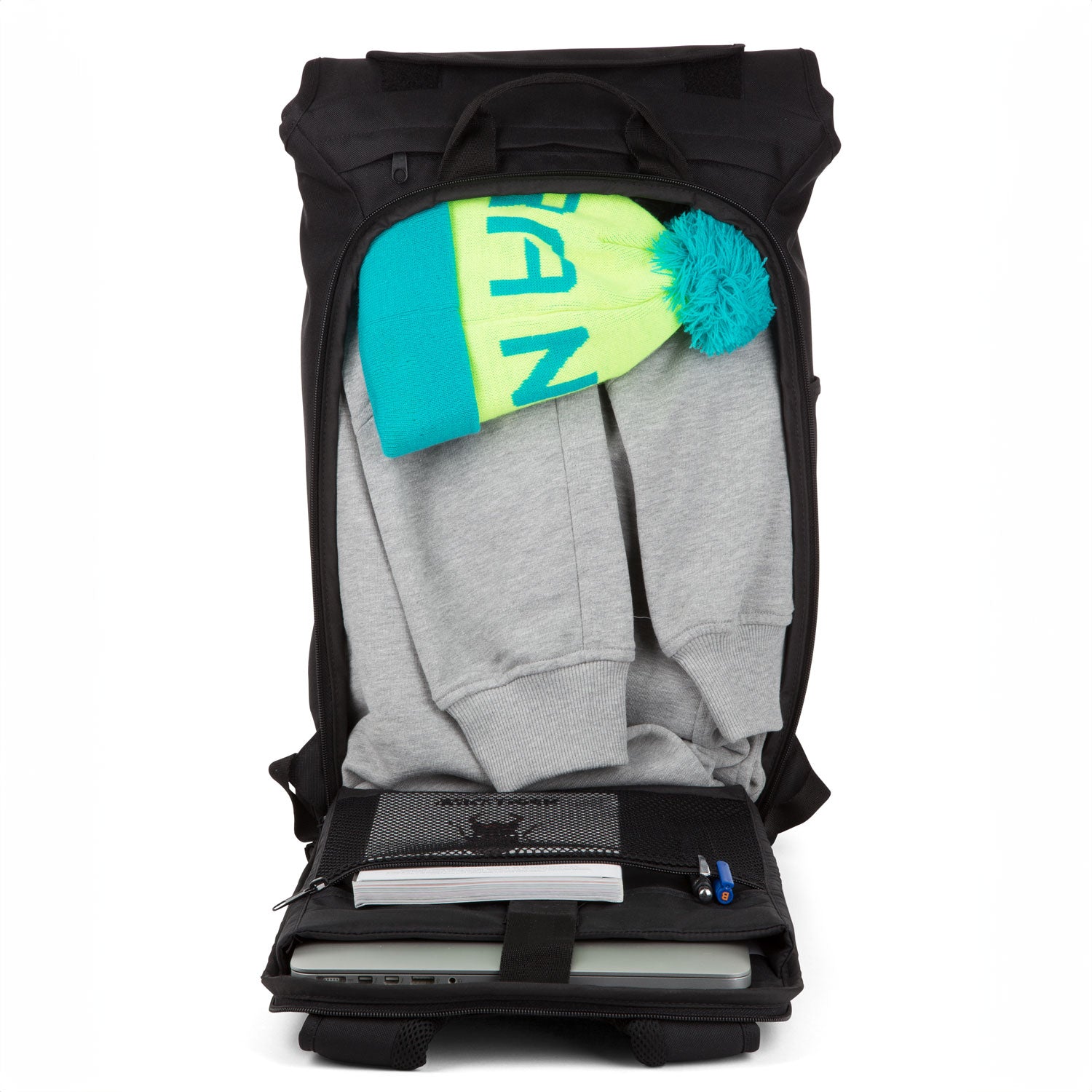 geöffneter aevor trip pack der eine mütze, einen Hoodie, einen Laptop, ein Buch und Kugelschreibe beinhaltet. 