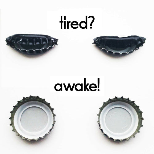 Vier Flaschendeckel sind zusehen, von denen die zwei oberen zusammengedrückt sind. Über ihnen steht "tired". Die zwei unteren sind in Normalform aufgedeckt mit der Überschrift "awake"